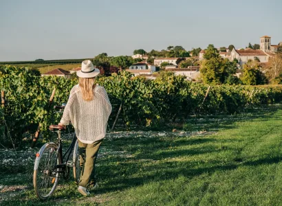 Girl walking a bike in a vineyard in Le Logis, Cognac region of France