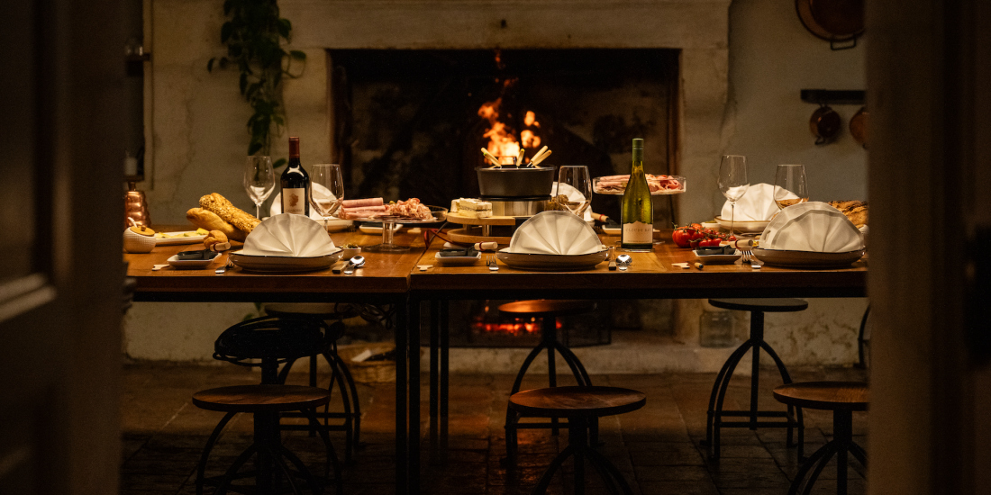 Fire side in charming Le Logis with a table full of delicious food and wine